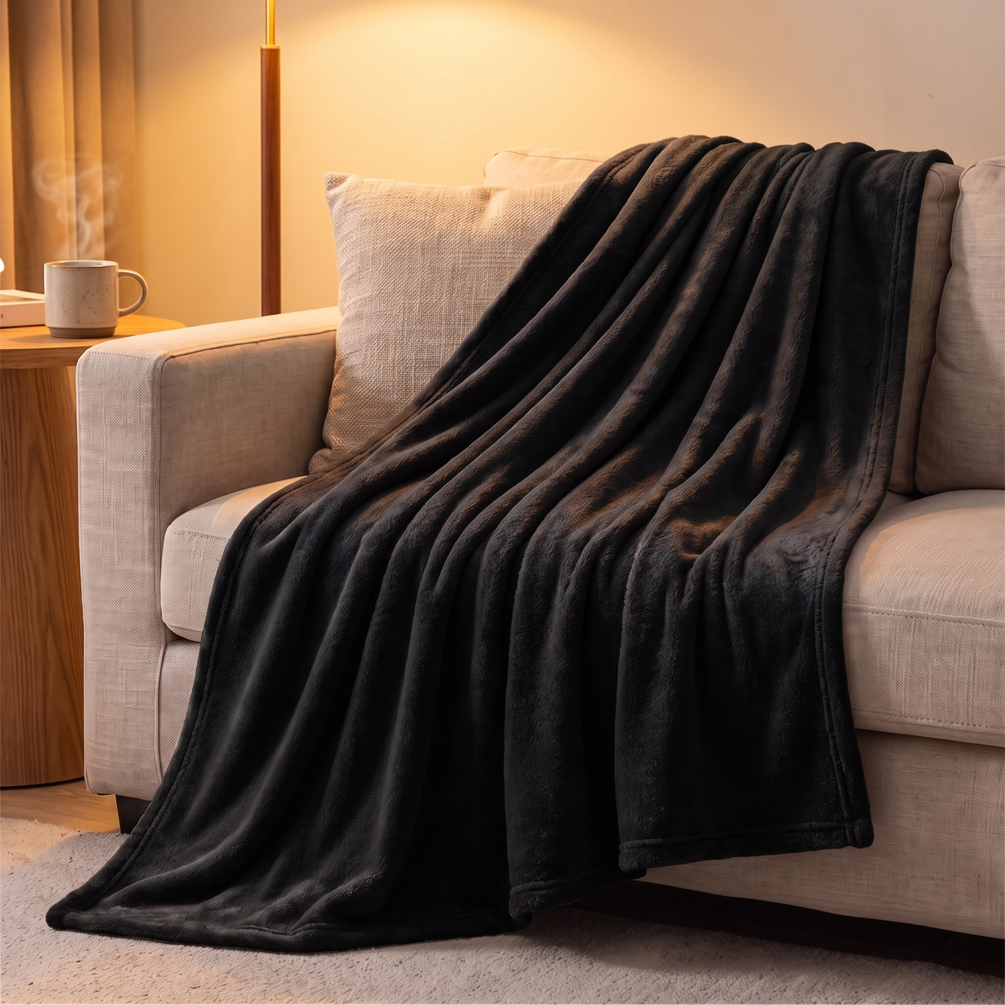 Schwarze Fleece Kuscheldecke über die Sofaecke drapiert im gemütlichen Wohnzimmer