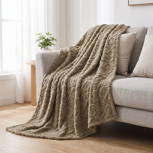 Kuscheldecke mit Zopfmuster in Taupe über einem Sofa im hellen Wohnzimmer