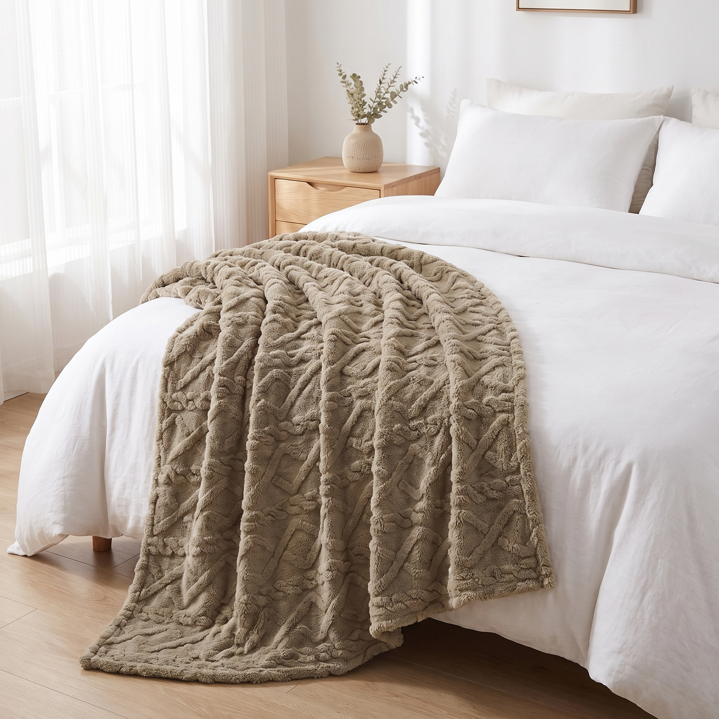 Kuscheldecke mit Zopfmuster in Taupe am Fußende eines Bettes im hellen Schlafzimmer