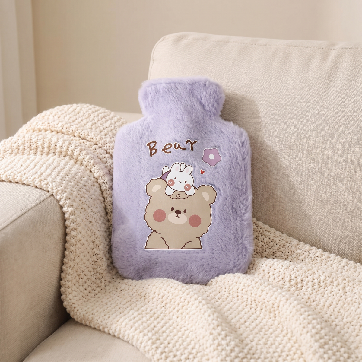 Mini Wärmflasche mit Plüschbezug in Lila auf einer Kuscheldecke