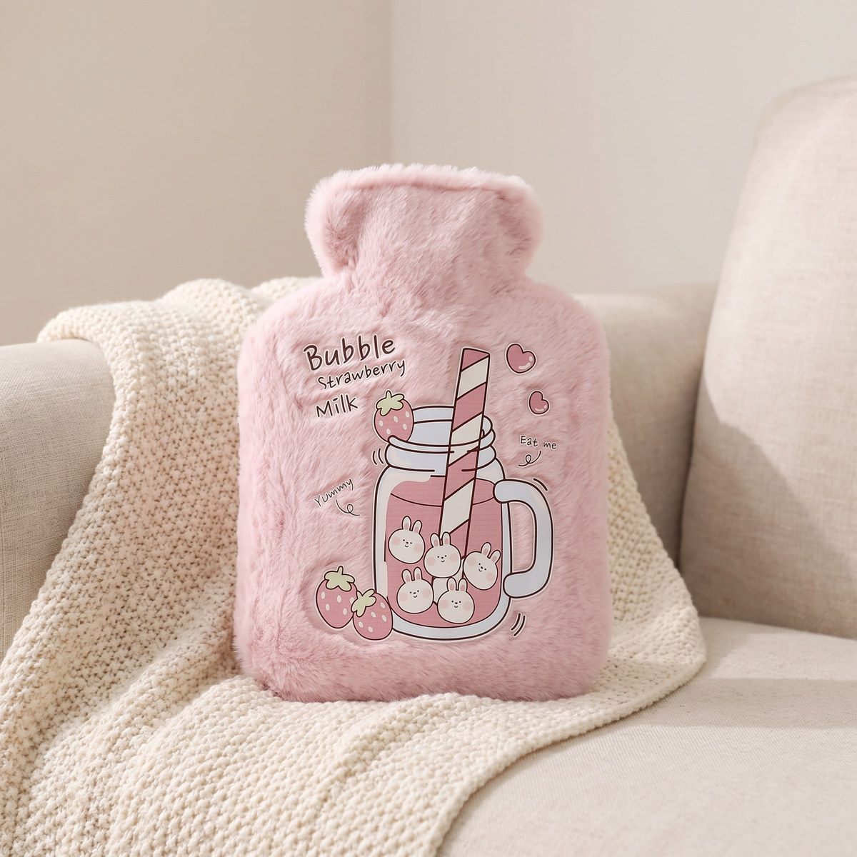 Mini Wärmflasche mit Plüschbezug in Rosa auf einer Kuscheldecke