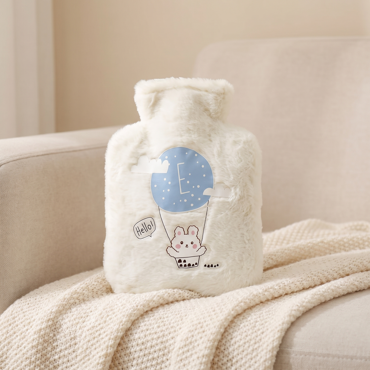 Mini Wärmflasche mit Plüschbezug in Weiß auf einer Kuscheldecke