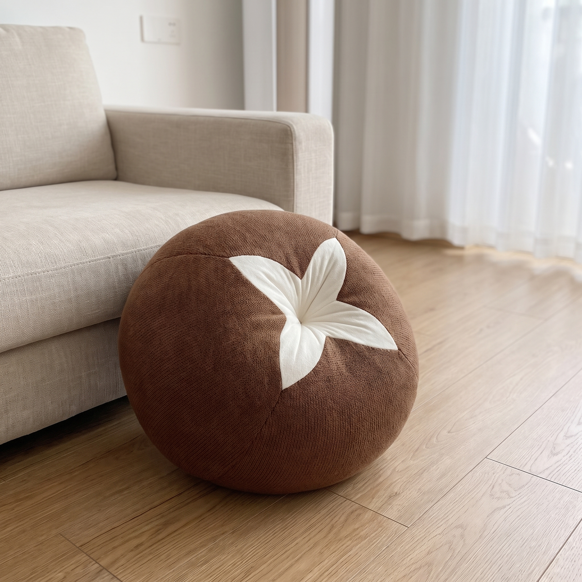 Rundes Faulenzerkissen in Braun auf dem Wohnzimmerboden neben dem Sofa