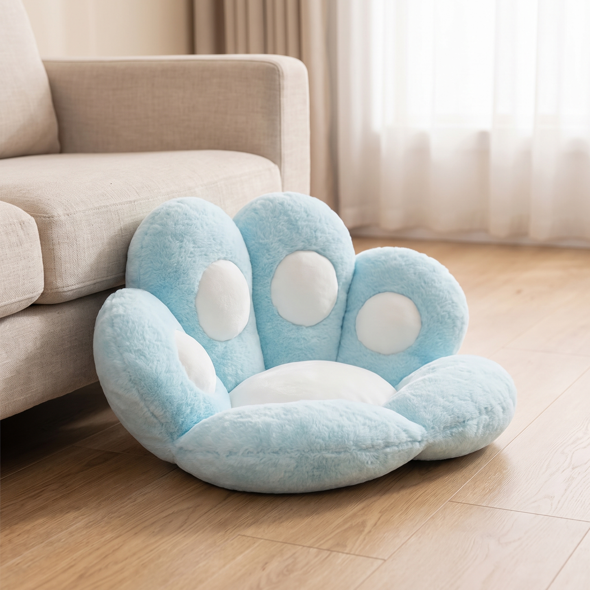 Plüschkissen Bärentatze in Blau auf dem Wohnzimmerboden